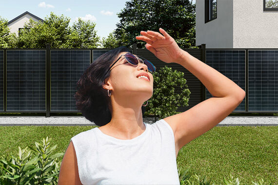 Woman enjoying a sunny day with Osmo Solar-Fence in her garden
